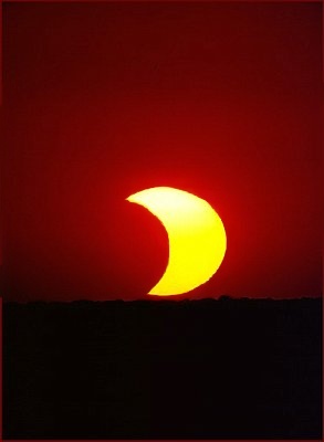 Picture of a partial solar eclipse at sunset.